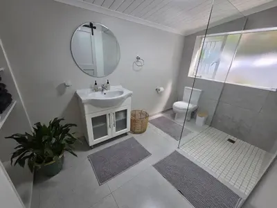 a bathroom with a shower and a sink and a mirror at SleepINN at Dumont in Paarl