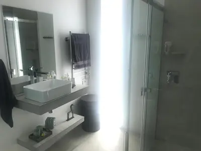 a white bathroom with a sink and a shower at Luxury Family Home in Helderberg