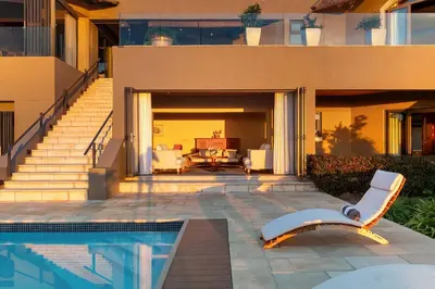 a house with a swimming pool in front of a house at Villa Bezweni in Somerset West