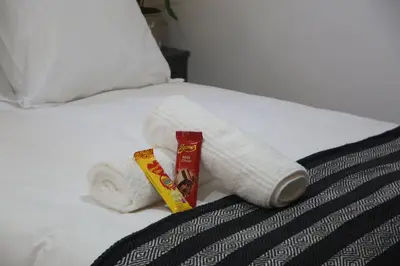 a white towel and a snack on a bed at Willow Brooks in Cape Town