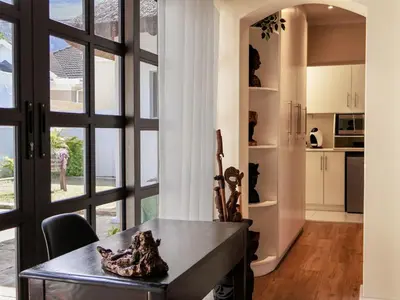 a dining room with a table and a large window at AFRICA WILD HERMANUS Luxury Self Catering Accommodation in Hermanus