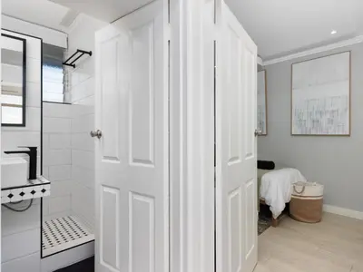 a white bathroom with a shower and a white door at Sandy Shores On Beach - 709 in Strand