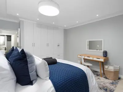 a bedroom with a bed and a desk and a television at Sandy Shores On Beach - 709 in Strand