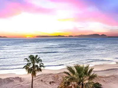 a beach with palm trees and the ocean at sunset at Sandy Shores On Beach - 709 in Strand