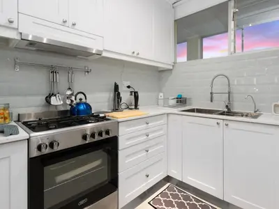 a white kitchen with a stove and a sink at Sandy Shores On Beach - 709 in Strand