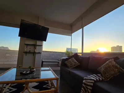 a living room with a couch and a glass table at Panorama Sea and Mountain Views in Strand