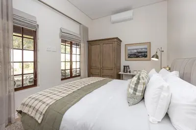 a bedroom with a white bed with white pillows at Villa Canetsfontein in Wellington