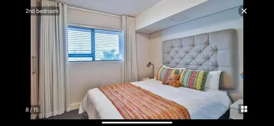 a bedroom with a large bed with a teddy bear on it at Waters Edge Sanctuary in Cape Town