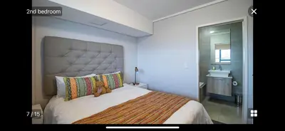 a bedroom with a large bed with a teddy bear on it at Waters Edge Sanctuary in Cape Town