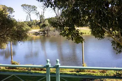 a view of a lake with a green fence at Patryssenvalleij Farm and Cottages in Stellenbosch