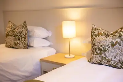 a hotel room with two beds and a lamp on a table at Patryssenvalleij Farm and Cottages in Stellenbosch