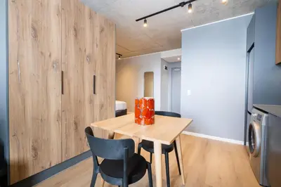 a dining room with a wooden table and chairs at 714 Riverlands - Lux Studio Apartment in Cape Town