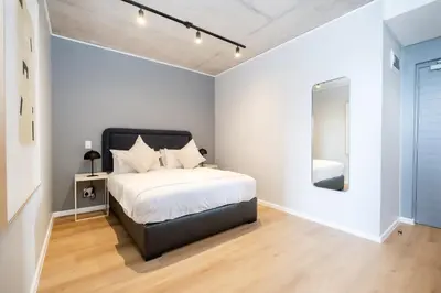 a bedroom with a bed and a mirror at 714 Riverlands - Lux Studio Apartment in Cape Town