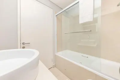 a white bathroom with a bath tub and a sink at Horizon Bay 303-Oceanfront Apt on Kite Beach with Balcony & Pool in Cape Town
