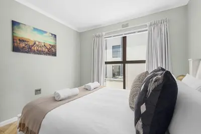 a bedroom with a large bed and a window at 17 Megans Place in Bloubergstrand
