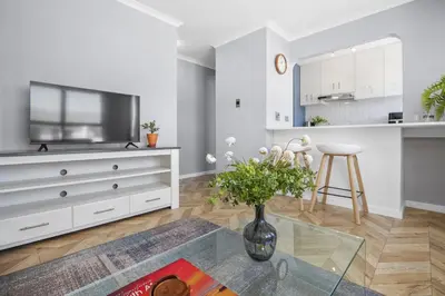 a living room with a vase of flowers on a table at 17 Megans Place in Bloubergstrand