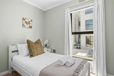 a bedroom with a bed with two towels on it at 17 Megans Place in Bloubergstrand