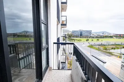 a balcony with a view of a road and buildings at 309 Riverlands - Lux 1 Bedroom Apartment in Cape Town