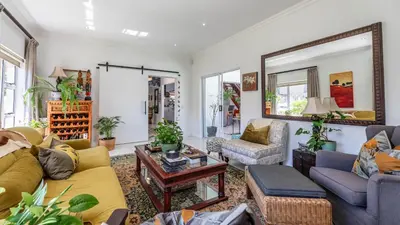 a living room filled with furniture and a mirror at Sunsets' Engina Villa, Sunset Beach in Cape Town
