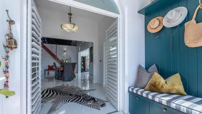 a hallway with blue and white walls and a zebra print rug at Sunsets' Engina Villa, Sunset Beach in Cape Town