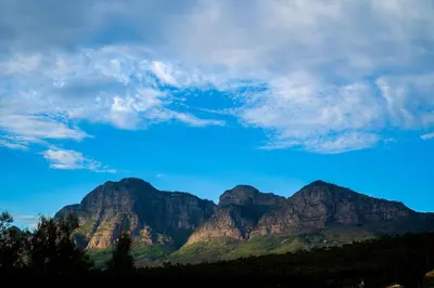a view of mountains with a blue sky and clouds at The Nest Franschhoek in Franschhoek