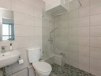 a bathroom with a toilet and a sink and a shower at 706 Odeon Towers - Ocean Splendour in Strand