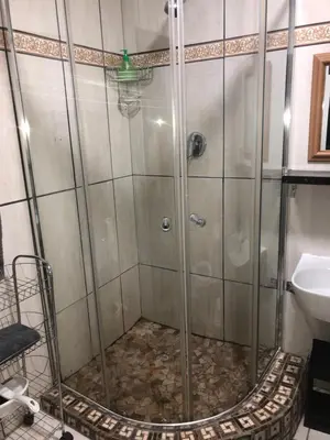 a shower with a glass door next to a sink at Relaxing Hideaway in Strand