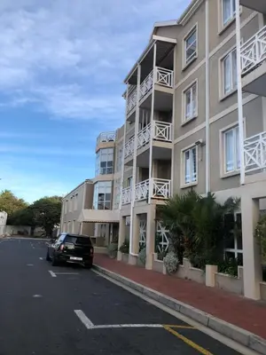 a car parked in a parking lot next to a building at Relaxing Hideaway in Strand
