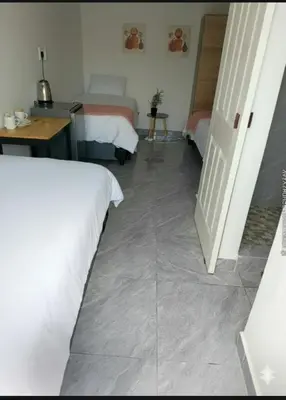 a bedroom with two beds and a tiled floor at 60 On Kosmos in Bellville South