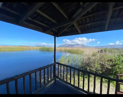 a view of a lake from a porch at Birds Nest Holiday Apartment in Zeekoevlei