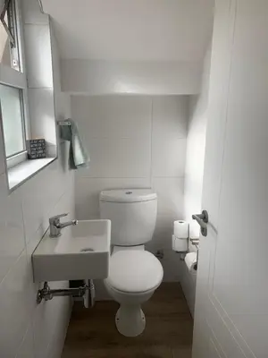 a white bathroom with a toilet and a sink at Cape Town in Cape Town