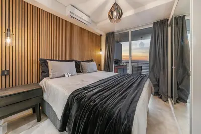 a bedroom with a large bed and a window at Beautiful 3 bed apartment with sea views Horizon Bay 502 in Cape Town