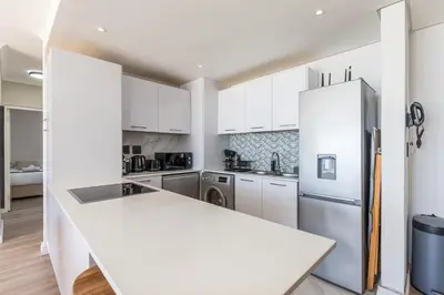 a kitchen with white cabinets and a refrigerator at Horizon Haven with stunning view by HMH 803 in Cape Town