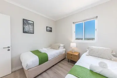 a bedroom with two beds and a window at Horizon Haven with stunning view by HMH 803 in Cape Town