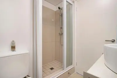 a shower with a glass door in a bathroom at Chic Beachfront Apt with Table Mountain Views Horizon Bay 902 in Cape Town