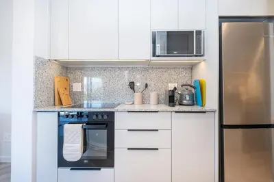 a kitchen with white cabinets and a black oven at 221 Paarl Lux 1 Bdrm Apt with Mountain Views in Paarl