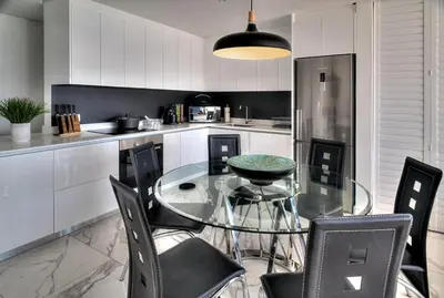 a kitchen with a glass table and black chairs at Horizon Bay 1302 Loadshedding Free APT by HMH in Cape Town