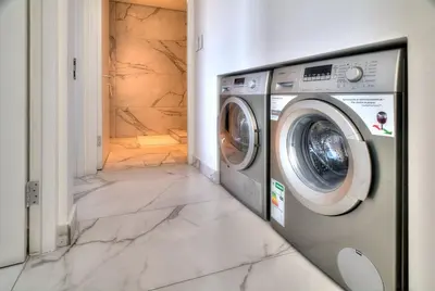 a washing machine in a laundry room with a marble floor at Horizon Bay 1302 Loadshedding Free APT by HMH in Cape Town