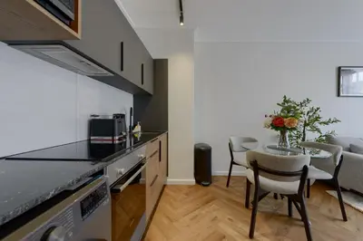 a kitchen and dining room with a table and chairs at Luxe On Park Century City in Cape Town
