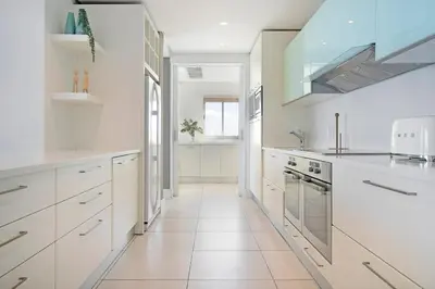 a white kitchen with white cabinets and a sink at Horizon Bay 1602 Penthouse APT with lovely views in Cape Town