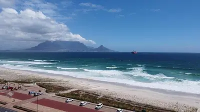 a group of cars parked on a beach near the ocean at Seaside Living on Kite Beach, Blouberg Sea Spray A204 in Cape Town
