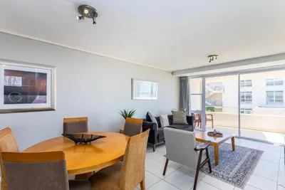 a living room with a table and a couch at Lagoon Beach 124A by CTHA in Cape Town