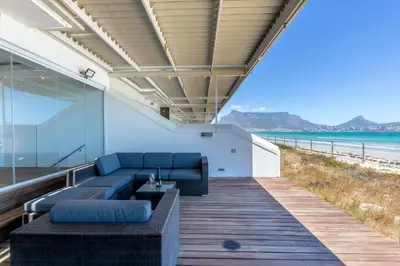 a living room with a couch and a view of the beach at Spinnakers 9 by HMH in Cape Town