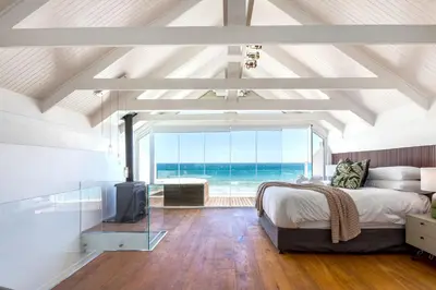 a bedroom with a bed and a view of the ocean at Spinnakers 9 by HMH in Cape Town