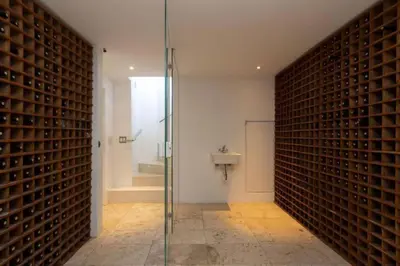 a bathroom with a glass shower and a wall of wine bottles at Spinnakers 9 by HMH in Cape Town