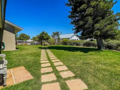 a stone path in a yard with a tree at Spacious mountain-view haven in Stellenbosch