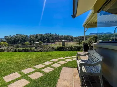 a bench sitting in a yard with a lawn at Spacious mountain-view haven in Stellenbosch