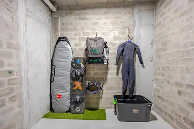 a room with a wall with snowboards and a bag at Beach Break Bliss - Cozy retreat with mountain views in Bloubergstrand
