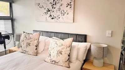 a bedroom with a bed with white sheets and pillows at 2 Bedroom, 4 Sleeper Hidden Gem Minutes from Blouberg Beach Front in Cape Town