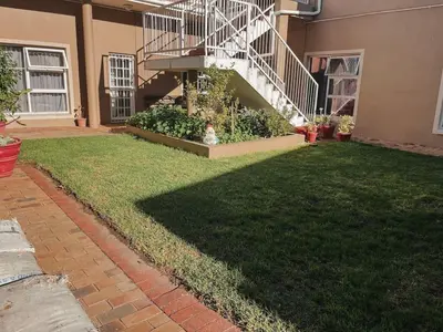 a yard with a staircase in a house at Cozy one bed, just a short walk to the beach in Strand